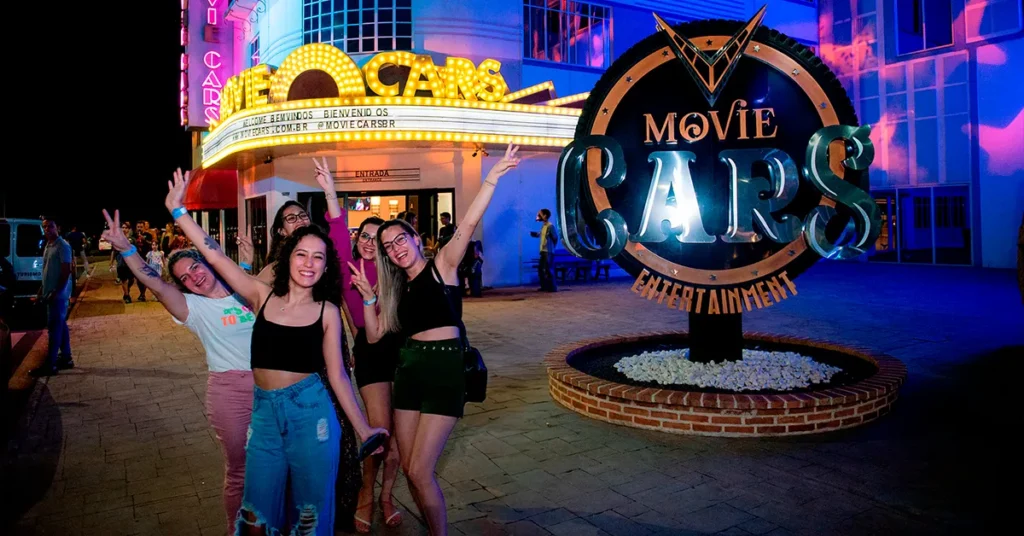 amigas tirando foto frente da placa do movie cars