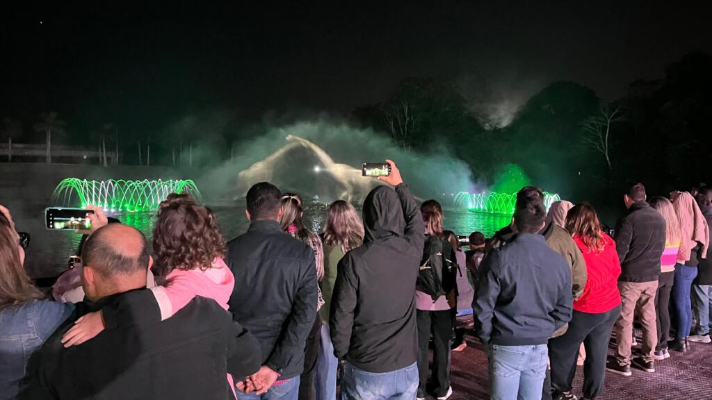 turistas e familia assistem o show das aguas