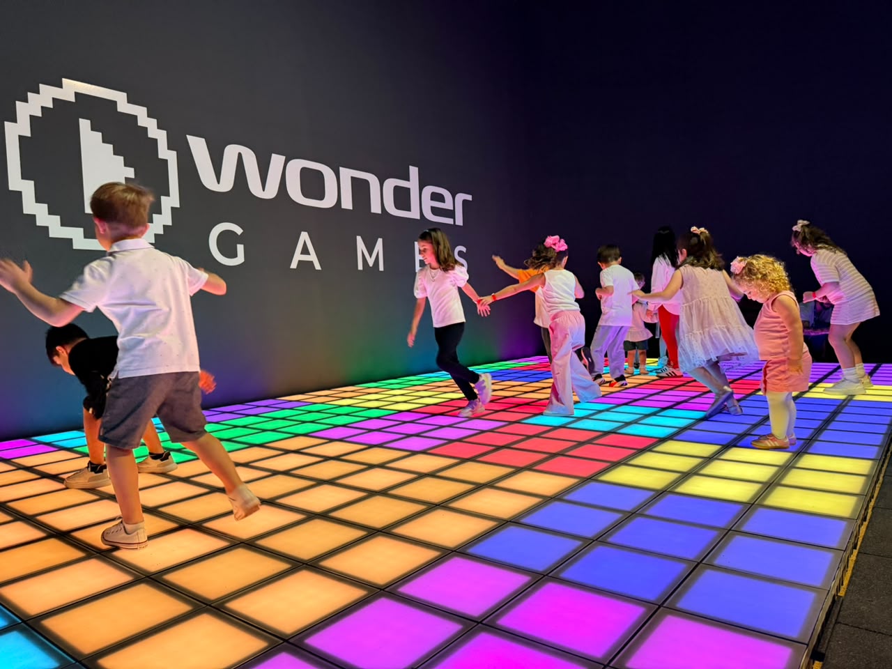 Piso de LED em cores de arco-íris sob o logotipo Wonder Games
