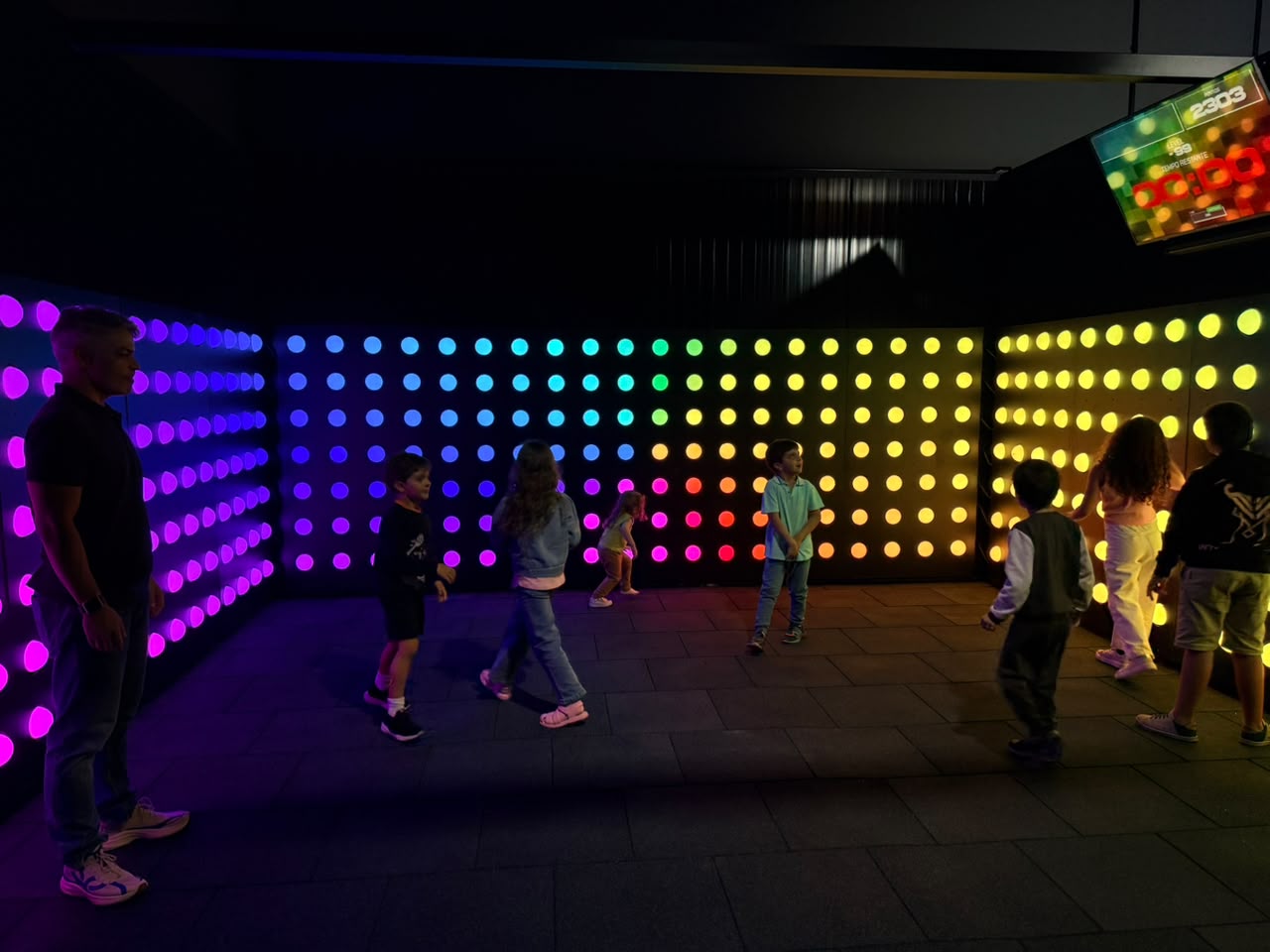 Parede de LED com pontos coloridos e placar digital