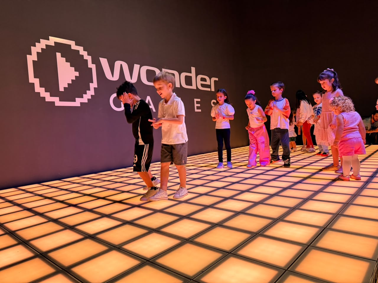 Grupo de crianças em partida sobre o piso de LED do Wonder Games