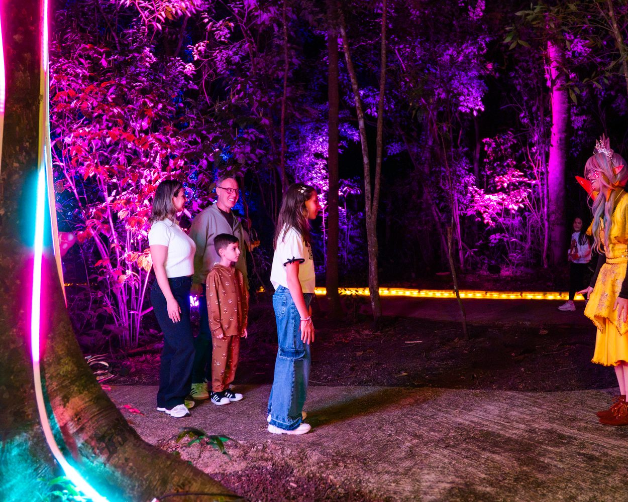 Família com personagem e a Árvore da Vida ao fundo no Lumina Park
