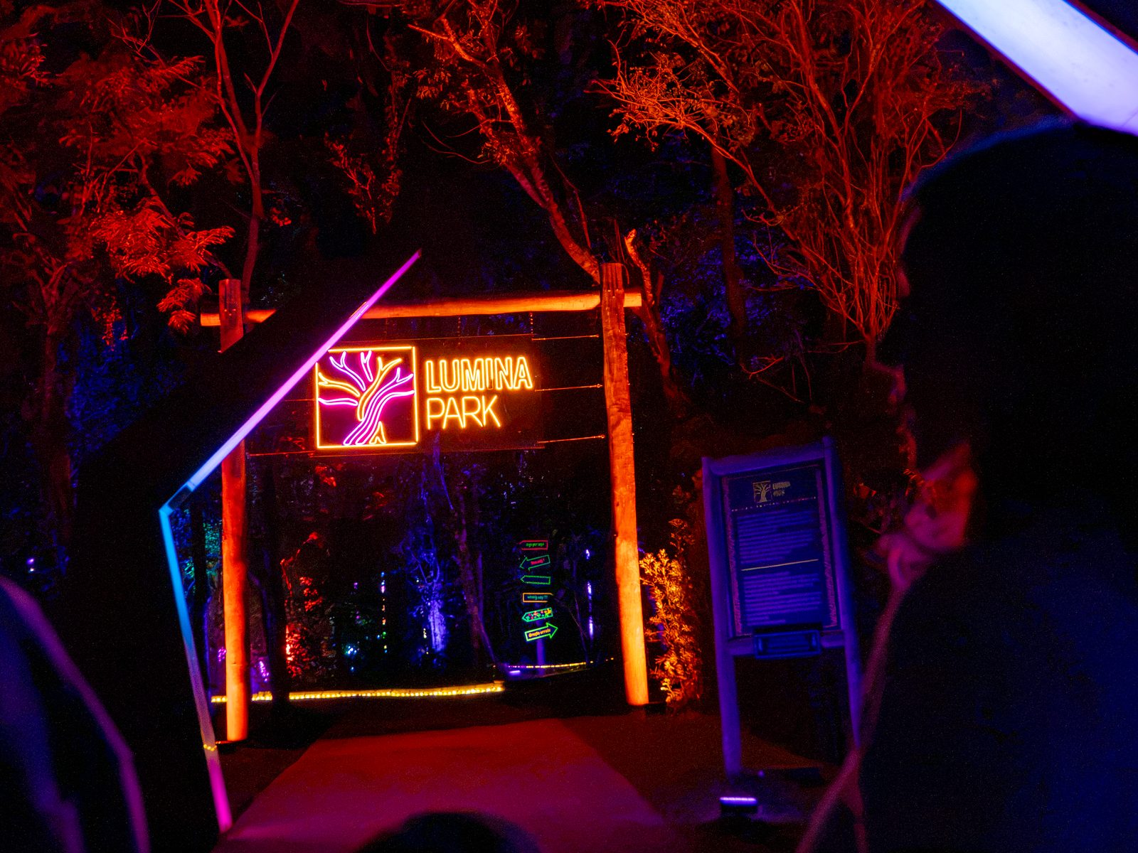 Letreiro de neon do Lumina Park na entrada da trilha