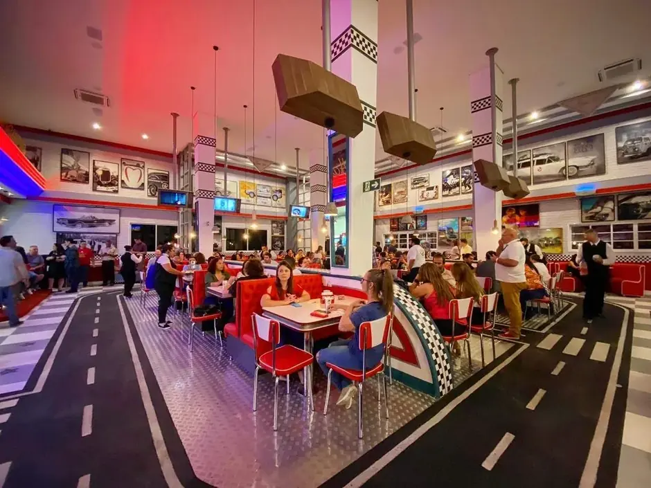 Salão do Bonnie's Burger com mesas de diner americano, decoração retrô e visitantes